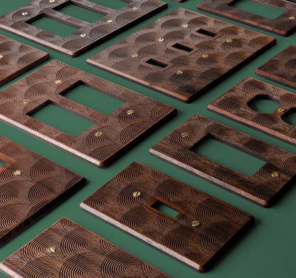 Rainbow Engraved Walnut Wooden outlet and Light Switch Plate covers with boho Rainbow design engraved into the surface to add texture. Plates are aligned vertically on a light green background. 